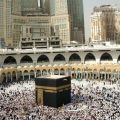 The Kaaba at the center of the Grand Mosque, surrounded by thousands of pilgrims in white ihram.