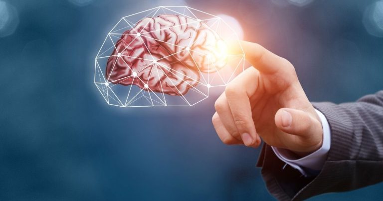 Hand in a suit finger-touches a glowing brain outlined by a geometric network, symbolizing AI or neural interfaces.
