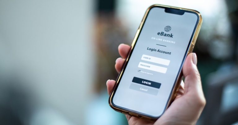 Mobile banking login screen on a smartphone showing user ID and passcode fields and a Login button.