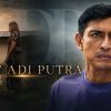 Movie poster for 'Dato'' Adi Putra' with a serious man in a purple shirt foreground and a couple beside a house at dusk, title text across the middle.